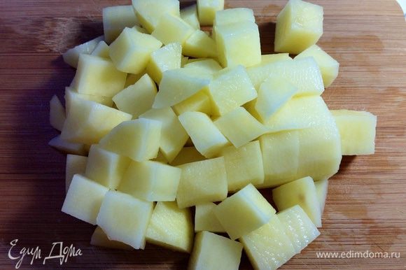 Крупный картофель (или два мелких) вымыть, очистить и нарезать кубиками среднего размера (как и курицу).