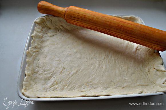 Тесто разморозить. Раскатать на слегка присыпанной мукой поверхности по размеру формы, оставляя немного теста на "бортики". Форму для выпечки смазать растительным маслом. Уложить тесто.