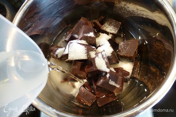 Только теперь переходим к приготовлению шоколадного мусса. Заранее готовить его не нужно! Смысл приготовления заключается в том, чтобы шоколадную массу сначала нагреть, а потом при резком охлаждении взбить ее до нужной консистенции. Итак, для мусса в сотейник выкладываем кусочки шоколада, сахар, коньяк (или другой крепкий напиток для вкуса) и наливаем воду.