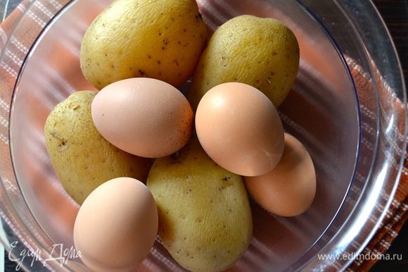 Первым делом отварить картофель "в мундире" и яйца в подсоленной воде, добавив ложечку уксуса. Остудить.