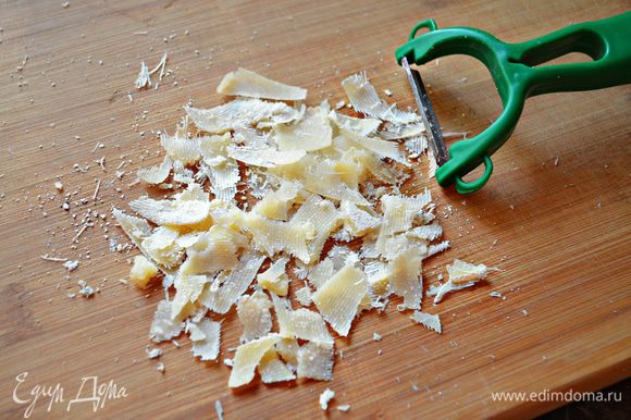 Пармезан (или любой другой твердый сыр) натрите на крупной терке или с помощью овощечистки и за 3 минуты до готовности посыпьте пирог сыром.