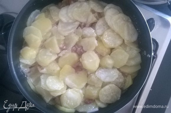 Берем сковороду (у меня Тефаль) или форму для запекания. Выкладываем слоями: половина лука с беконом, сверху половина картофеля, затем снова лук с беконом и наконец покрываем оставшимся картофелем.