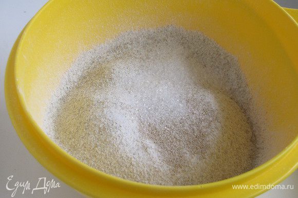 Пшеничную и ржаную муку просеять в миску. Добавить сухие дрожжи, соль и сахар. Все перемешать.