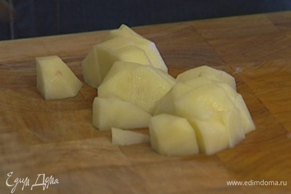 Картофель почистить, мелко порезать, добавить в кастрюлю с луком и чесноком и немного прогреть, чтобы он пропитался маслом.