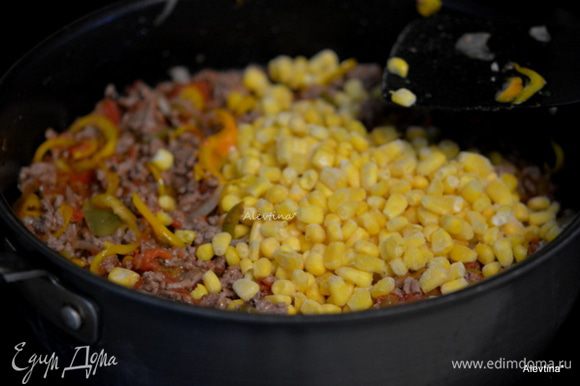 Вернуть сковороду на огонь. Добавить овощную сальсу домашнюю или покупную, нарезанные баночные томаты в собственном соку, замороженную кукурузу. Помешивать и готовить 8 мин.