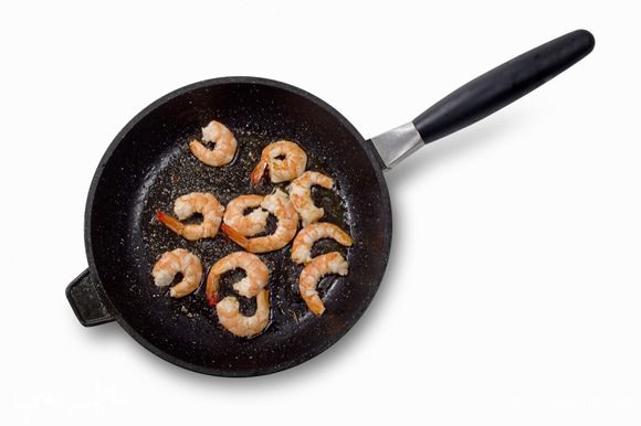 Очищенные креветки быстро обжарить на сковороде с небольшим количеством оливкового масла.