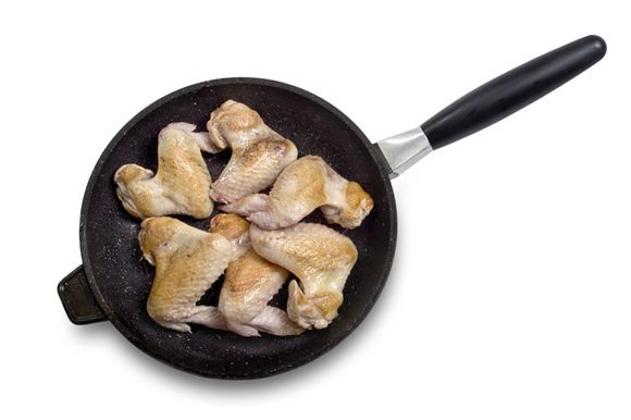 Куриные крылышки быстро обжарить на сильном огне до золотистой корочки. Переложить их в кастрюлю. Залить литром воды и поставить вариться примерно на полтора часа (пока мясо не начнёт отделяться от костей).