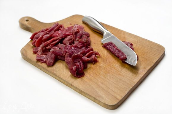 Мясо нарезать на тонкие полоски. Для того, чтобы это было легче сделать, можно предварительно на 30 минут положить его в морозилку.