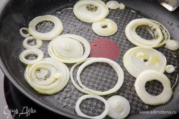 Готовим начинку. В большой сковороде на среднем огне разогреваем оливковое масло. Добавляем нарезанный кольцами лук и обжариваем его до мягкости около 5 минут.