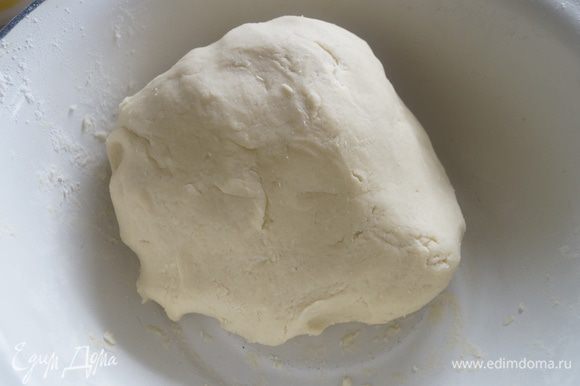 Муку смешать с разрыхлителем и небольшими порциями добавить в тесто. Замесить тесто, сформировать из него гладкий шар. Завернуть в пищевую пленку и убрать в холодильник на 30 минут.