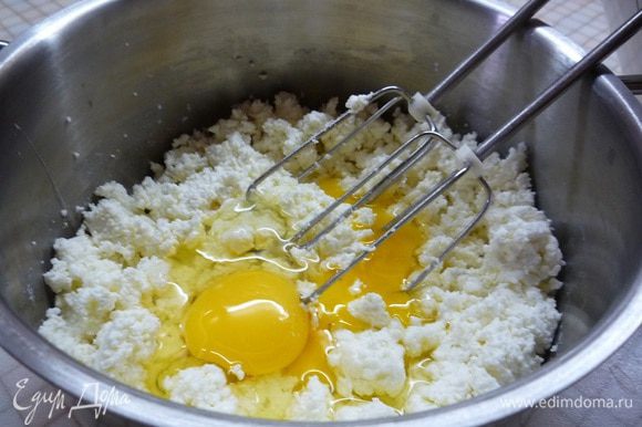 Творог выкладываем в чашку, добавляем яйца и взбиваем до однородности.