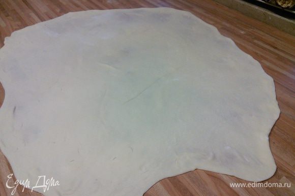 На посыпанной мукой поверхности раскатайте тесто в пласт 25 × 40 см, затем руками начинайте его растягивать до размера примерно 50 × 80 см.