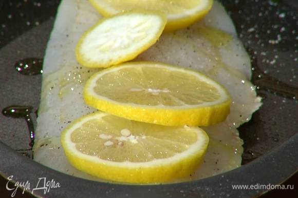 Половинку лимона нарезать кружками и поместить на рыбу. Отправить форму в разогретую духовку на 7 минут.