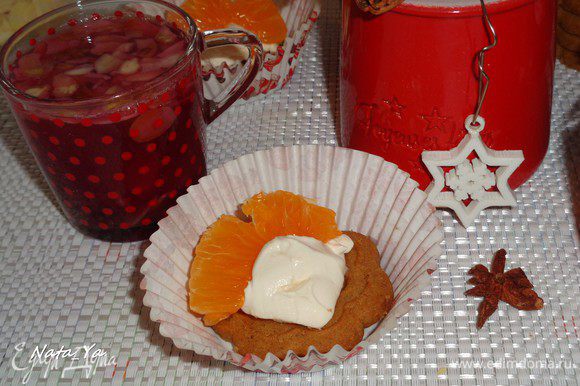 Пряничное печенье намазать сырным кремом и украсить очищенными от пленок дольками мандаринов.