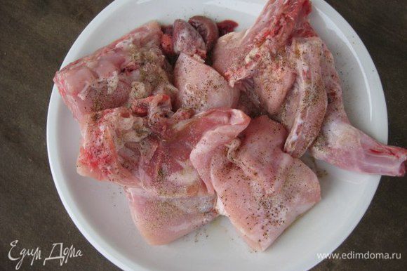 Кролика разрезать на порционные куски, сложить в миску, сбрызнуть уксусом, оливковым маслом, посолить, посыпать специями. Оставить мариноваться мясо на полчаса.