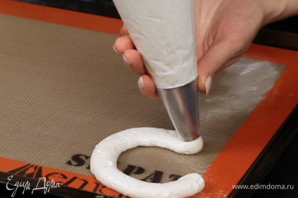 Переложите массу в кондитерский мешок и отсадите на пекарскую бумагу круги нужного размера.