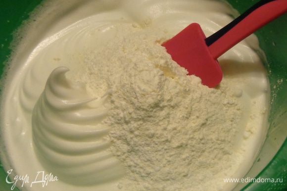 Смешать и просеять сахарную пудру с мукой и по частям с помощью лопатки ввести эту смесь в белки.