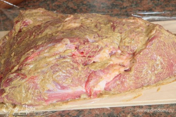 Переворачиваем мясо на подготовленную пищевую пленку и обмазываем маринадом другую сторону мясного куска.