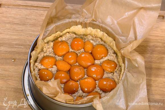На подпеченный корж тонким слоем выложить марципановую массу, а затем половинки абрикосов срезом вниз.