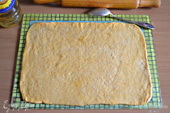 Раскатать тесто в прямоугольный пласт, смазать растительным маслом и посыпать сахаром (по 1 ст. л. с горкой на каждый пласт).