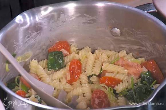 Выложить помидоры с луком и шпинатом в горячую пасту, влить пару ложек воды, в которой варились макароны, и все перемешать.