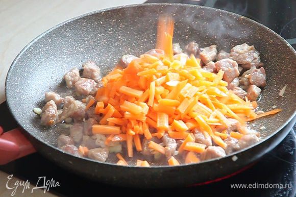 Открываем крышку, перемешиваем мясо с луком, доливаем растительное масло из нашего стаканчика и выкладываем нарезанную соломкой морковь.