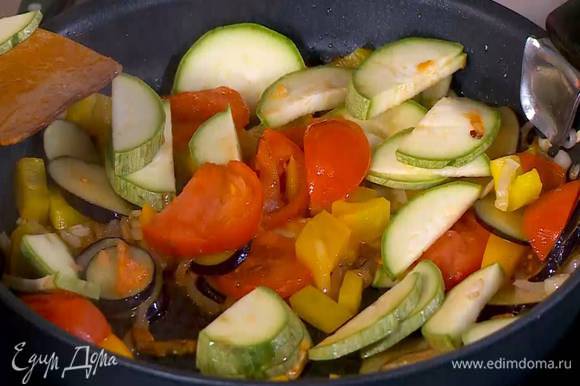 В сковороду с овощами добавить помидор и кабачок, слегка посолить, перемешать и все обжарить.