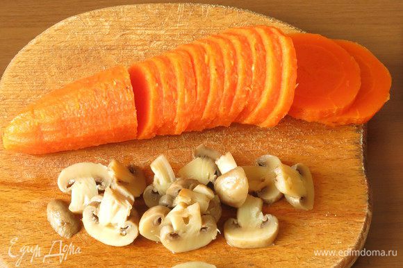 Нарезаем морковь и грибы. Можно использовать фигурную нарезку. Грибы в заливное используем не все, но уменьшать количество не рекомендую, бульон будет не такой насыщенный.