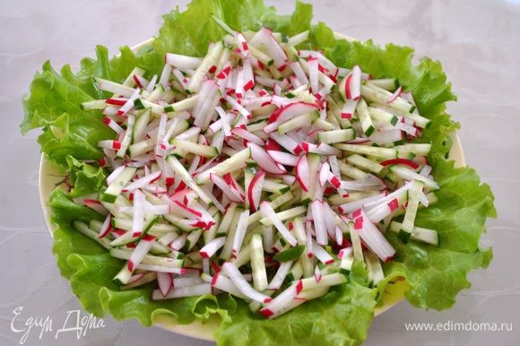 Начинаем собирать салат. На блюдо выкладываем листья салата, выкладываем огурцы и редис.