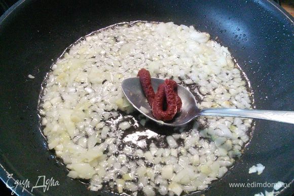 В горячем масле пассеруем лук и чеснок, добавляем томатную пасту, обжариваем в течении одной минуты.