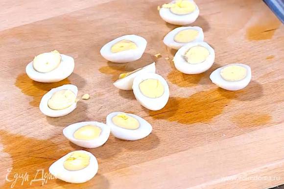 Отварить 6 перепелиных яиц вкрутую, затем почистить и разрезать пополам.