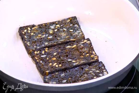 Разогреть в сковороде 1 ст. ложку оливкового масла и обжарить черный хлеб с двух сторон, затем выложить его на бумажное полотенце.