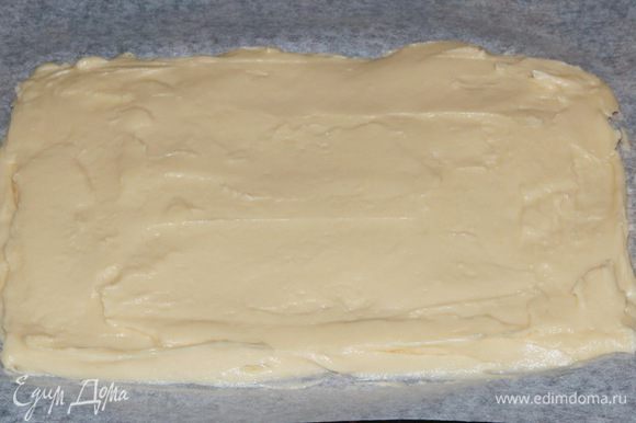 Противень выстилаем пекарской бумагой и равномерно распределяем тесто.