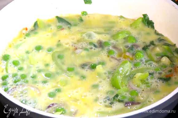 Яйца слегка взбить венчиком и влить в сковороду с овощами.