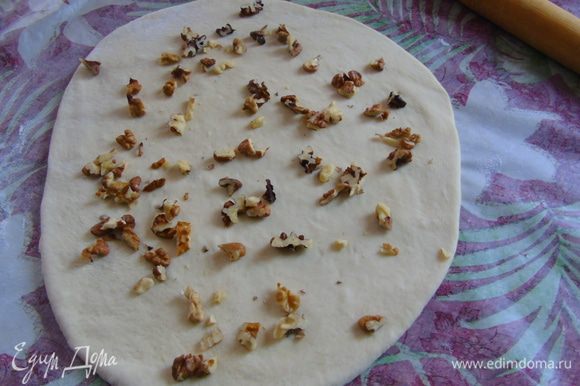 Раскатываем белое тесто и посыпаем половиной орехов.