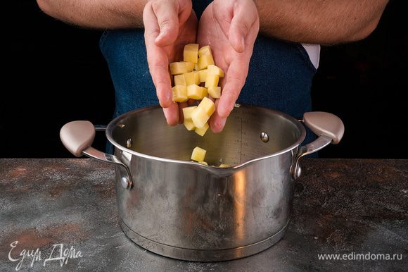 Очистите картофель, порежьте кубиками и добавьте в кастрюлю, обжарьте 5 минут.