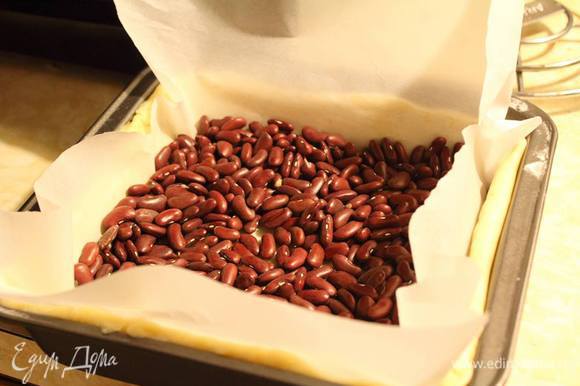Внутрь на пекарскую бумагу выложить фасоль и отправить в разогретую до 180°С духовку на 15 минут.