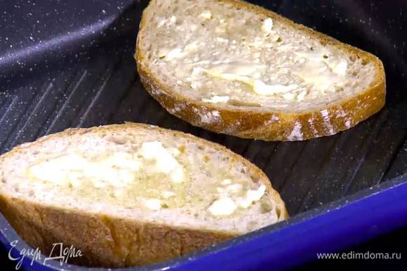 Хлеб подсушить с одной стороны на разогретой сковороде-гриль, затем перевернуть и смазать поджаренную сторону предварительно размягченным сливочным маслом.