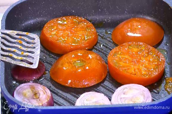 Разогреть в сковороде-гриль 1‒2 ч. ложки оливкового масла и обжаривать лук и помидоры с двух сторон до появления золотистой корочки.