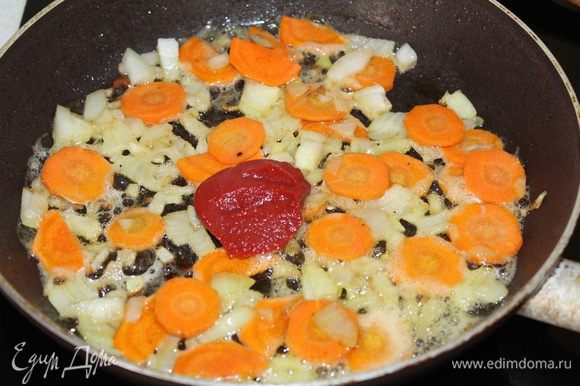 Мясо отложить в тарелочку, а в этом же масле слегка обжарить мелко нарезанный лук и морковь кружочками, затем добавить томатную пасту (мне нравится томатная паста «Помидорка»).