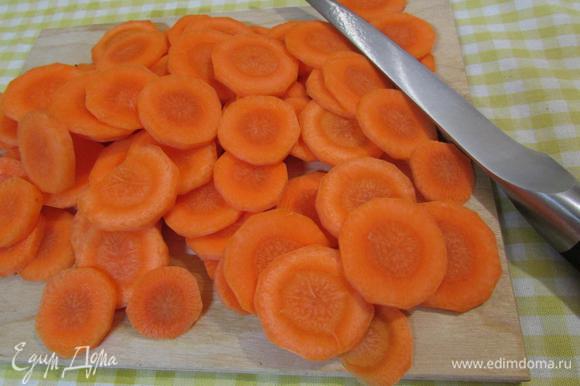 Через 25 минут в бульон с мясом добавить морковь, нарезанную колечками. Продолжать тушить еще 20 минут.