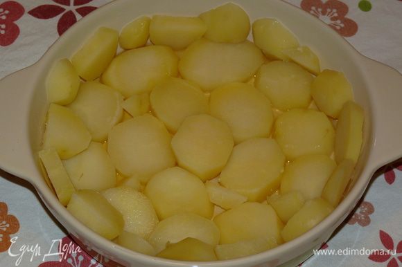 Форму для запекания смазать растительным маслом. Картофель крупно нарезать и уложить на дно формы.