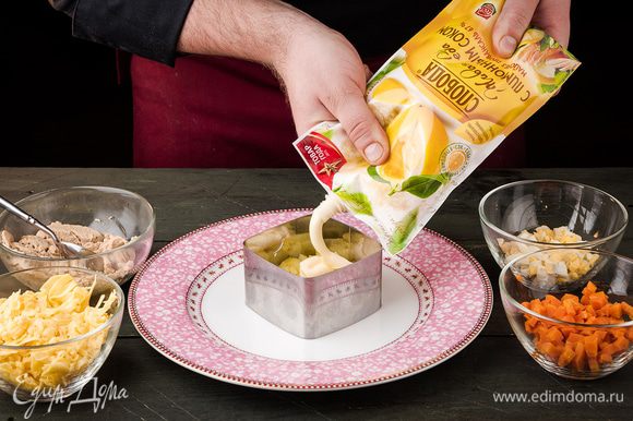 В сервировочное кольцо выложить картофель, смазать майонезом С лимонным соком ТМ «Слобода».