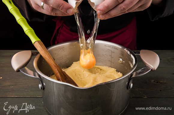 Охладить тесто. Постепенно вводить яйца. Вымешивать тесто, пока оно не станет вязким.