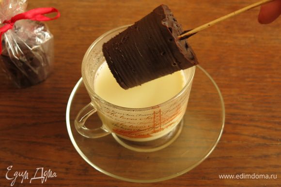 Снимаем стаканчик, чуть надрезаем и легко освобождаем шоколад. Опускаем шоколад на палочке в горячее молоко.