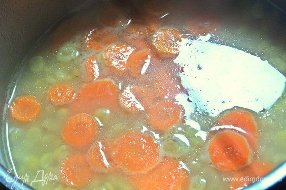 Всыпать замоченный горох. Позже добавить морковь, нарезанную любым способом.
