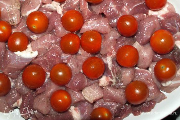Свинину перекладываем в жаропрочную посуду, сверху укладываем помидоры черри.