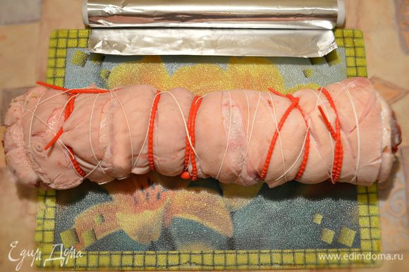 Сверните кусок мяса в плотный рулет. Затем свяжите рулет кулинарной нитью, жгутами, зафиксировав его форму.