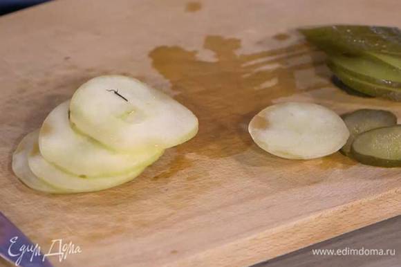Маринованный огурец и моченое яблоко нарезать тонкими ломтиками.