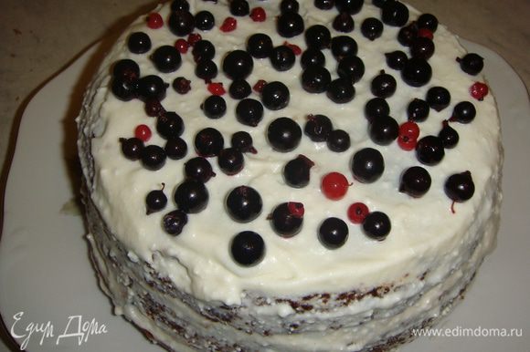 Верх и бока торта смазать оставшимся кремом (без ягод) и сверху выложить смородину. Торт убрать в холодильник на пару часов.